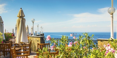 Terrasse med bord og stol. Utsikt mot Amalfis kyst