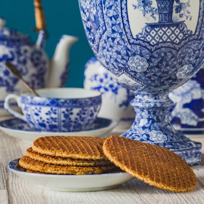 Tradisjonell nederlandsk stroopwafel med sirup, informasjonskapsel og te, Delfts blå dekorativ servise satt på bordet, nærbilde, makrofoto