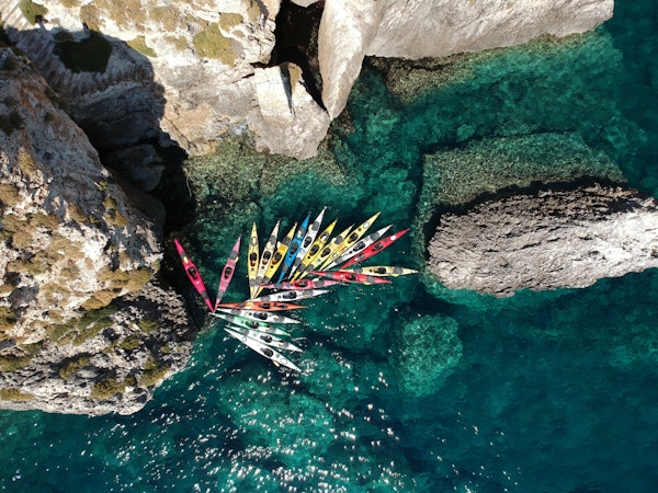Fargerike kajakker i en trang bukt i havet utenfor Kefalonia