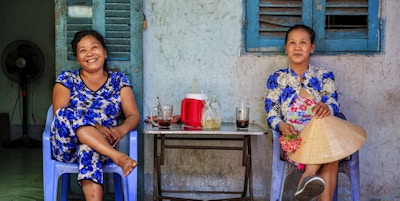 To vietnamesiske kvinner som drikker kaffe sammen, Mekong River Delta, Vietnam