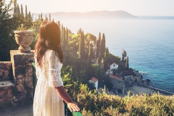 Kvinnelig reisende nyter en naturskjønn utsikt over Adriaterhavskysten i Trsteno, Dalmatia, Kroatia. Dette er en turistattraksjon nær gamlebyen i Dubrovnik.