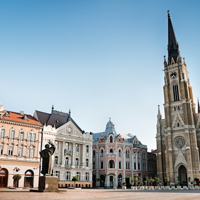 "Det sentrale torget i Novi Sad, Serbia eller Trg Slobode. Synlig er tradisjonell arkitektur, parochial romersk-katolske kirke med navnet Marias og statuen av Svetozar Miletic. Se flere bilder som dette i:"