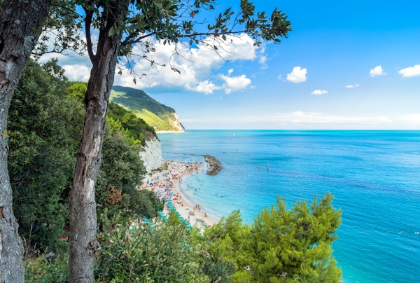 dags utsikt over den berømte stranden overfylt med turister i Sirolo, Italia.