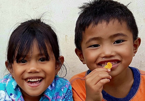 To barn som smiler mot kameraet i nærbilde