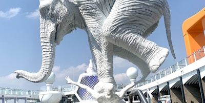 Skulptur av mann med hvit elefant på ryggen.