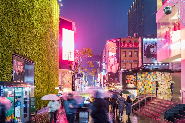 SEOUL, Sør-Korea - 26. november 2017: Folk som går med paraplyer på en regnfull dag på Myeong-dong shoppinggate om natten, Seoul, Sør-Korea