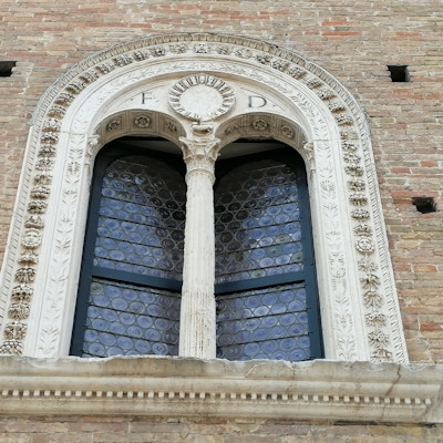 Et detaljert og utsmykket vindu på Ducale-palasset i Urbino sett fra utsiden