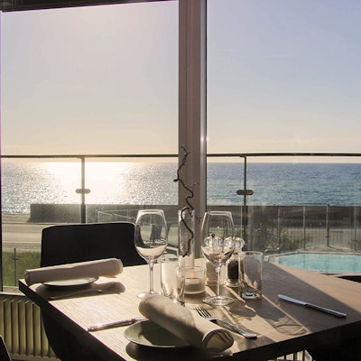 Dekket bord i restaurant, med utsikt over sjøen