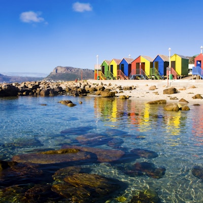Krystallklart vann fra St James Beach og tidevannsbasseng med sine fargerike hytter, Cape Town, Sør-Afrika