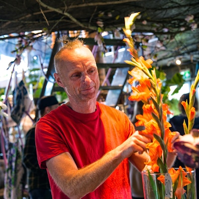 Mann som ordner til en blomsterbukett i en vase