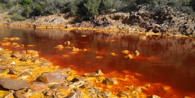 Vann med rødfarge fra mineraler fra gruvedrift