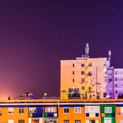 Fargerike bygninger oppført i mur under en stjerneklar kveldshimmel
