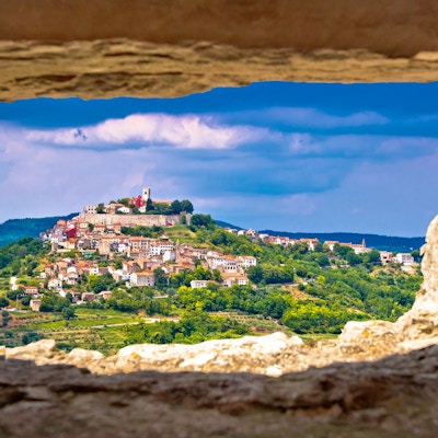 Byen Motovun på den pittoreske toppen av Istria, Kroatia, sett gjennom steinvindu