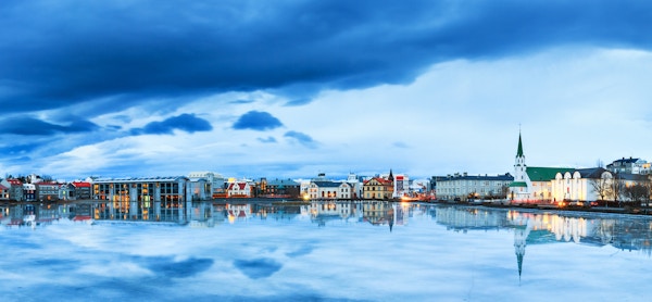 Nydelig panorama av bybildet i Reykjavik, reflektert i Tjornin-sjøen på den blå timen om vinteren