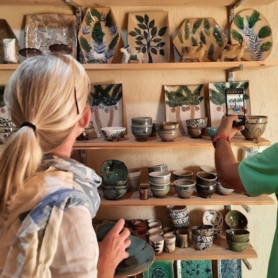 To personer står inne i et utsalg og ser på lokal keramikk
