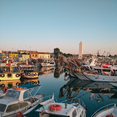 Mange båter ligger til havn i Fano under solnedgangen