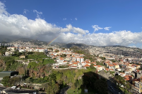 Utsiktsbilde over en by med en regnbue på himmelen