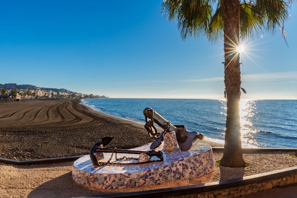Rincon de la Victoria-stranden i Malaga, med et monument med skipsankre på strandpromenaden til minne om dens sjøfarende fortid.