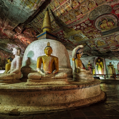 Buddha-statue inne i Dambulla-huletempelet, Sri Lanka. Dambulla huletempel også kjent som Golden Temple of Dambulla er et verdensarvsted på Sri Lanka, som ligger i den sentrale delen av landet. Dette stedet ligger 148 km øst for Colombo og 72 km nord for Kandy. Det er det største og best bevarte huletempelkomplekset på Sri Lanka. Dette tempelkomplekset kan dateres tilbake til det første århundre f.Kr. Det er mer enn 80 dokumenterte grotter i området rundt. De viktigste attraksjonene er spredt over 5 huler, som inneholder statuer og malerier. Disse maleriene og statuene er relatert til Lord Buddha og hans liv. Det er totalt 153 Buddha-statuer, 3 statuer av srilankanske konger og 4 statuer av guder og gudinner.