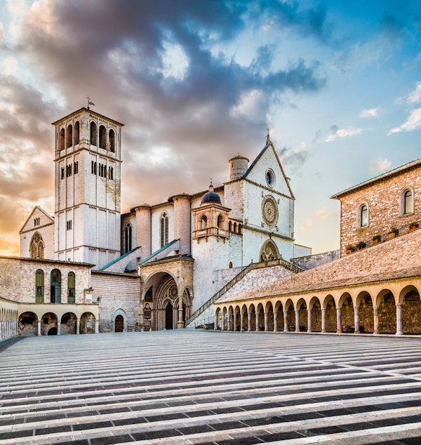 Berømte basilikaen St. Francis of Assisi (Basilica Papale di San Francesco) med Nedre Plaza ved solnedgang i Assisi, Umbria, Italia.