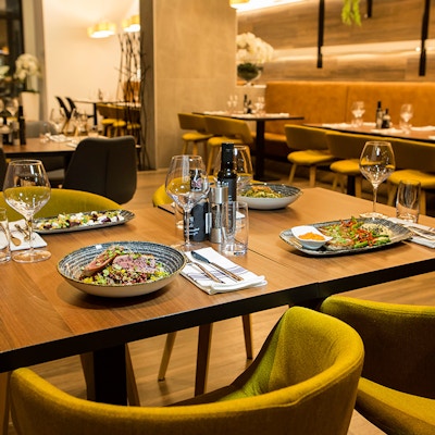 Bord i restaurant dekket til middag med matretter og glass