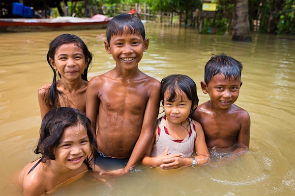 Barn har det gøy i vannet under flom nær Tonle Sap Lake i Kambodsja. Tonle Sap er den største ferskvannsjøen i Sørøst-Asia, og er et økologisk hotspot som ble utpekt som en UNESCO-biosfære i 1997