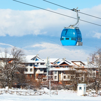 Skianlegg i Bansko, Bulgaria panorama med gondolheis, snødekte fjell og hus om vinteren