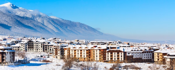 Trehytter, hus og snøfjelllandskapspanorama i det bulgarske skianlegget Bansko, Bulgaria