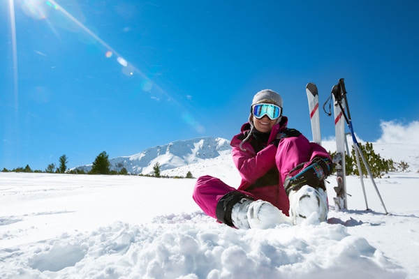 Kvinnelig skiløper som hviler i skiløypa