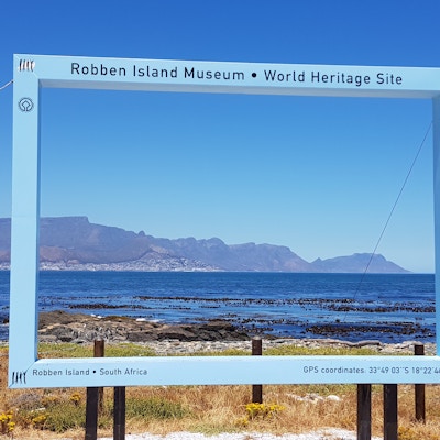 Et rektangel med teksten Robben Island viser utsikten tilbake til byen