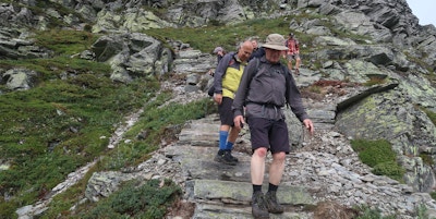 En gruppe mennesker går steintrappene ned fra Birihorn-fjellet