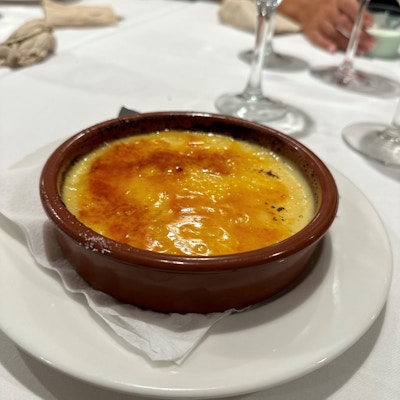 Spansk dessert i brun skål oppå en hvit tallerken