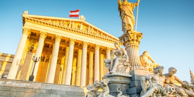 Den østerrikske parlamentsbygningen med statuen Athena i front i Wien ved soloppgangen