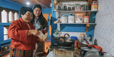 Bhutansk bestemor lærer barnebarnet sitt å lage tradisjonell mat hjemme