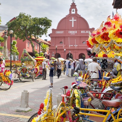 Christ Church Melaka. En populær historisk turistattraksjon i Melaka Malaysia med blomsterdekorerte trehjulssykler til leie.