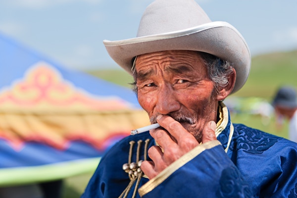 Mongolsk mann i nasjonal klesdrakt under Naadam-festivalen, Sentrale Mongolia. Naadam er den mest sette festivalen blant mongoler, og antas å ha eksistert i århundrer i en eller annen form. Naadam har sitt opphav i aktiviteter som for eksempel militære parader og sportslige konkurranser som bueskyting, ridning og bryting, som fulgte med i feiringen ved forskjellige anledninger.