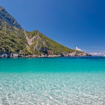 Skikkelig klart vann på ei gresk øy med fjell og grønt i bakgrunnen