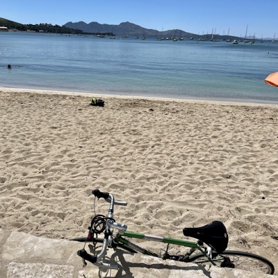 Sykkel lagt inntil siden av en strand i bakgrunnen av hav