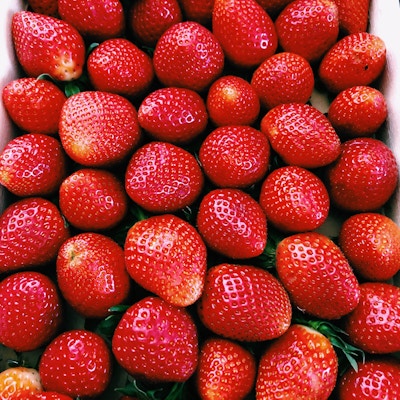 En boks med magne friske, røde, flinsende jordbær