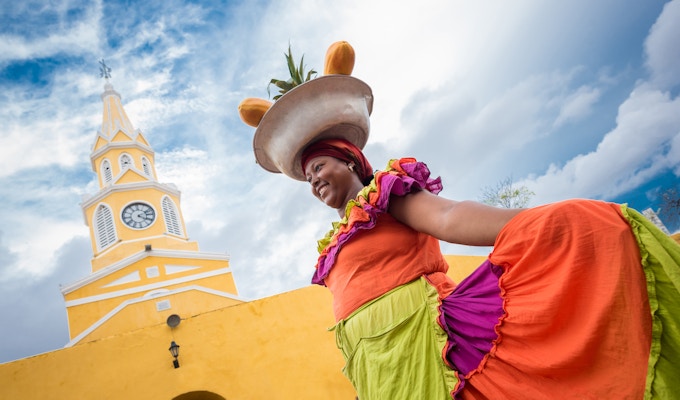 Glad Palenquera som selger frukt i Cartagena - reise som et lokalt konsept