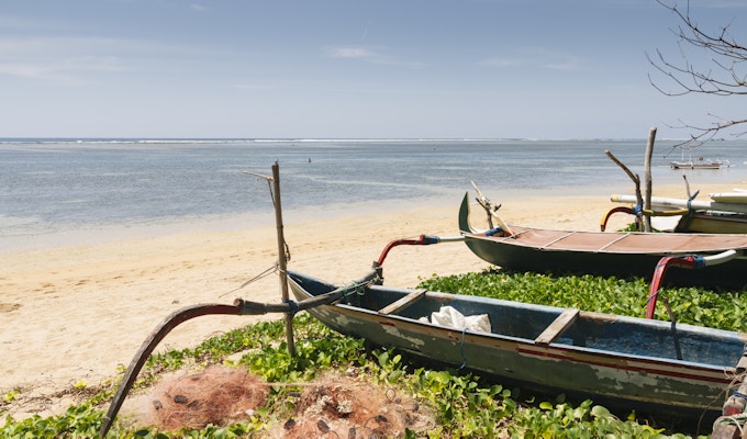 Gamle fiskebåter fortøyd på stranden ved Sanur, Bali, Indonesia