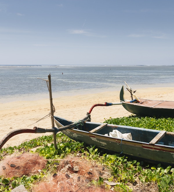Gamle fiskebåter fortøyd på stranden ved Sanur, Bali, Indonesia