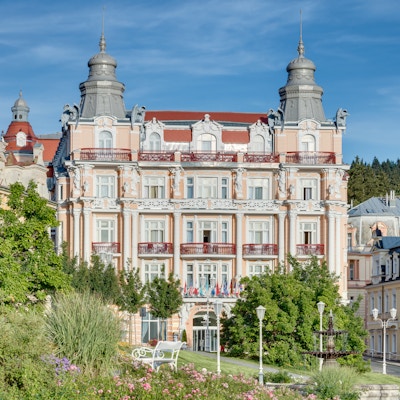 Ærverdig hotellbygning med spir og pastellfarget fasada