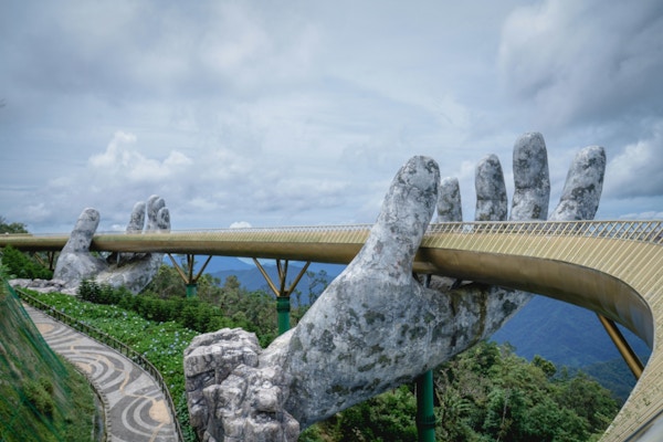 en gyllen bro ser ut til å holdes oppe av to store hender i Vietnam