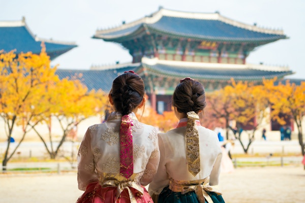 Koreansk dame i hanbokkjole går og reiser i palass i Seoul by, Sør-Korea