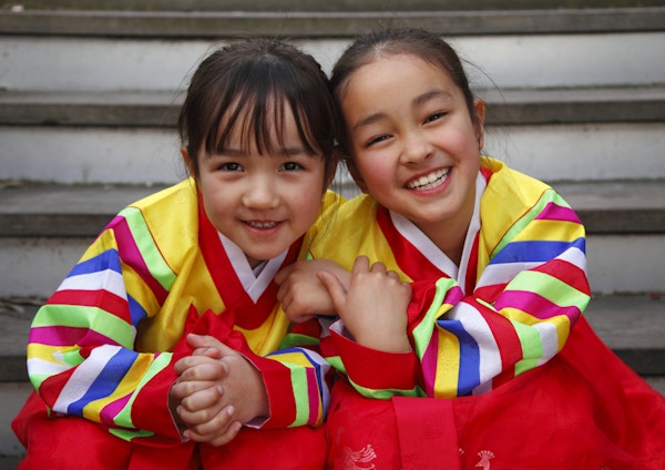 Glade jenter i tradisjonell koreansk kjole (hanbok).