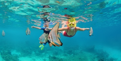 Lykkelig familie - mor, barn i snorkelmaske dykk under vann, utforsk tropiske fisker Platax ( Batfish). Reiselivsstil, strandeventyr, svømmeaktivitet på sommeren med barn. Fokus på fisk