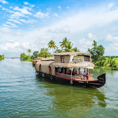 Liten båt som seiler på en kanal i Kerala