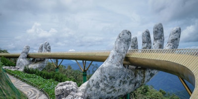 en gyllen bro ser ut til å holdes oppe av to store hender i Vietnam
