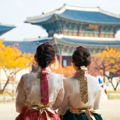 Koreansk dame i hanbokkjole går og reiser i palass i Seoul by, Sør-Korea